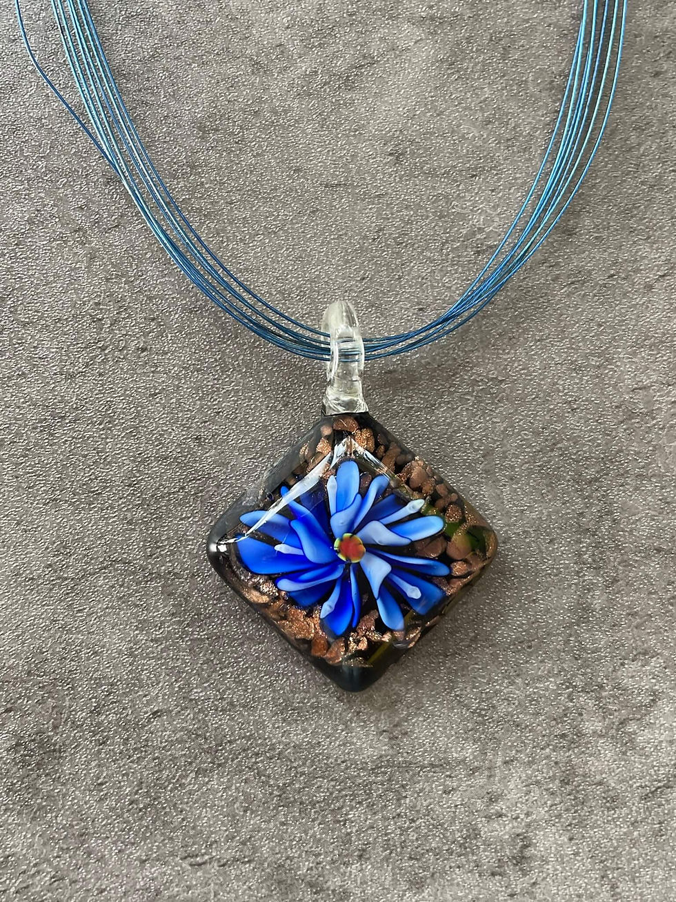 Square glass pendant necklace close up view showing vibrant blue flower detail and subtle gold sparkle