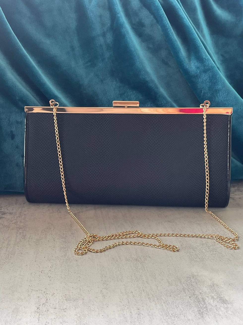 New Look Textured Clutch – front view with gold clasp and detachable long gold chain strap displayed against satin backdrop