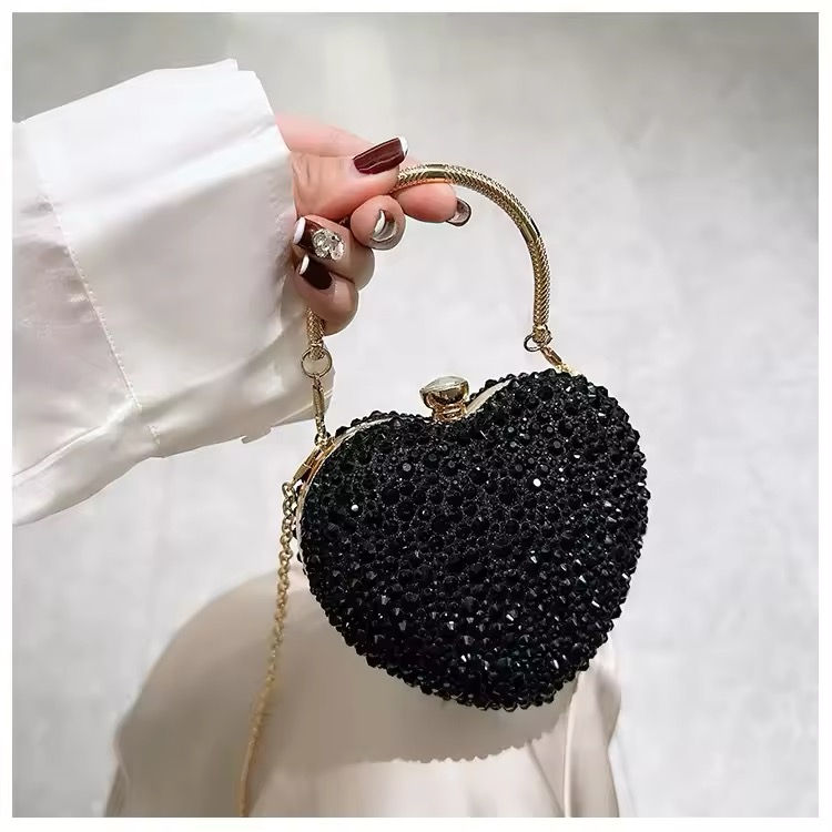 Thumbnail: Woman holding beaded heart-shaped purse with gold handle, elegant fashion accessory.