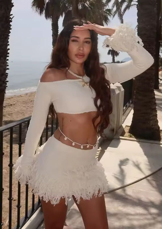 Thumbnail: Woman in white Contrast Bow Knit Dress smiling near the ocean, wearing LUV RUSH.