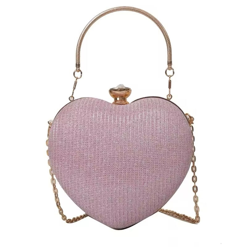 Прев'ю: Heart-shaped pink handbag with gold handle and strap against white background.