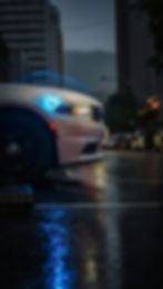 White Dodge Charger driving in rain at night