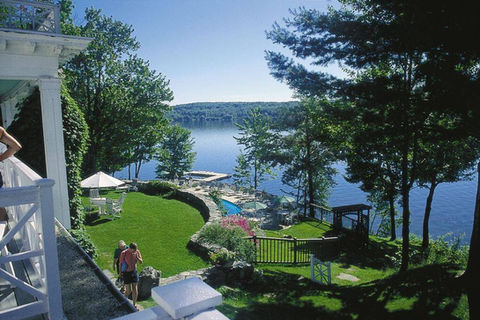 Lakeside resort view: pool, lawn, and guests