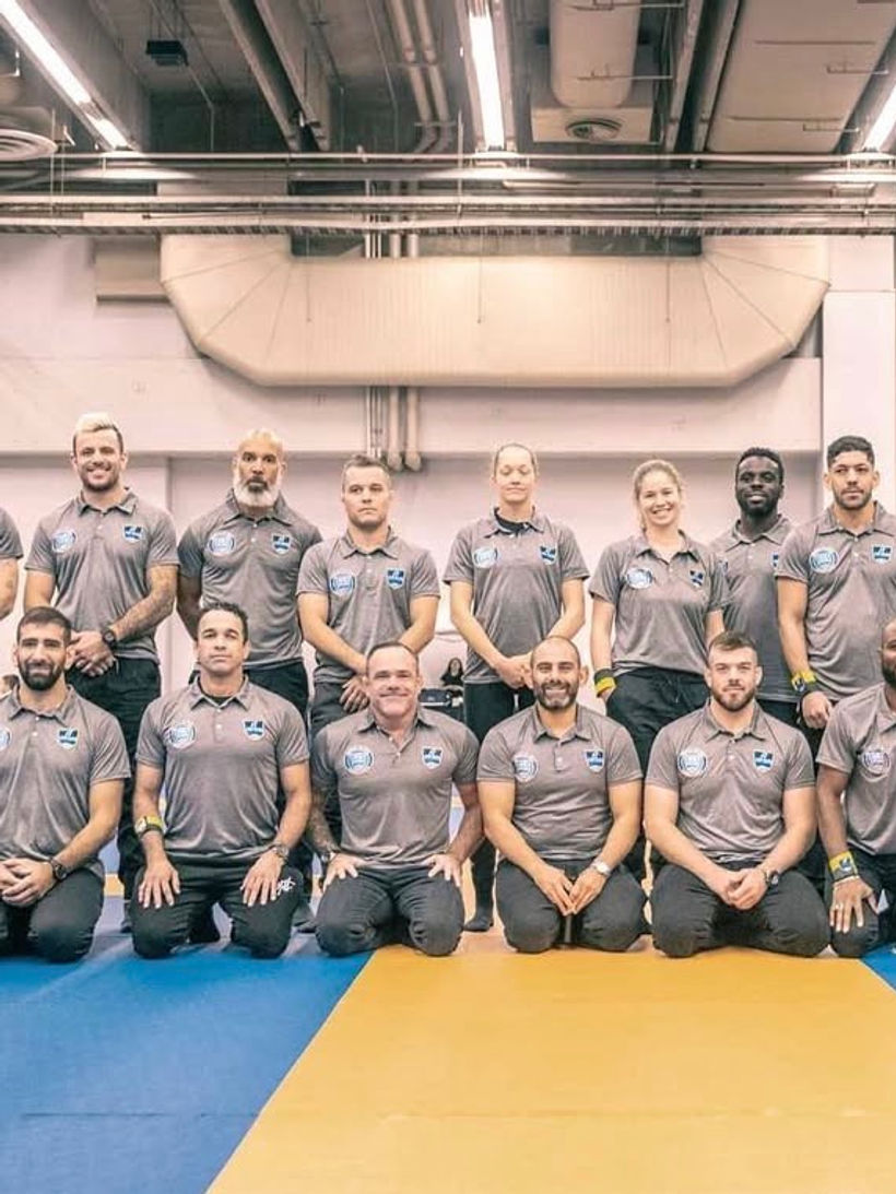 Groupe de personnes en uniforme gris sur un tapis de sport.