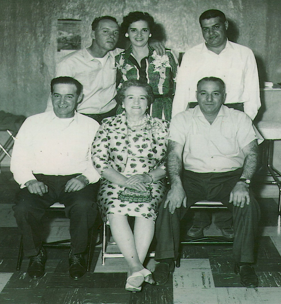 Vintage photo of six people, three men standing, two men and a woman seated.