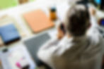Man on phone at desk with documents and folders, working.