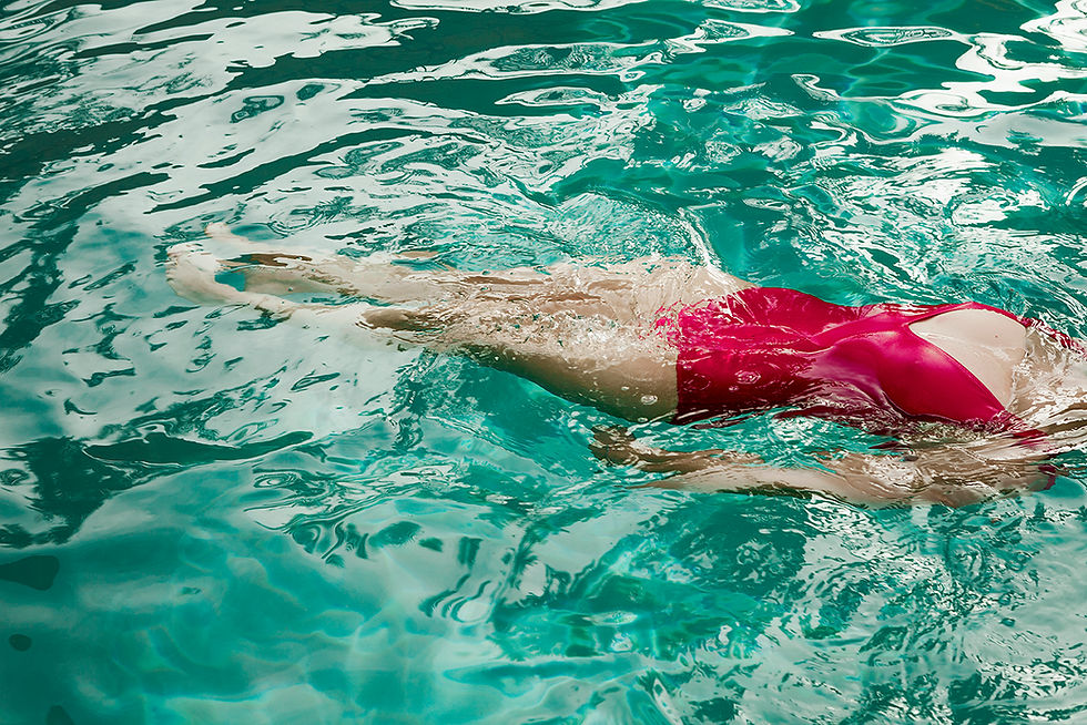 Personne en maillot rose nageant sous l'eau