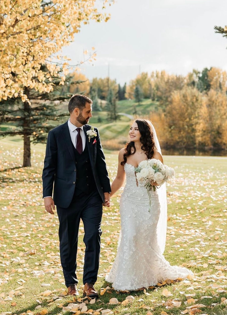 Happy couple holding hands, autumn wedding