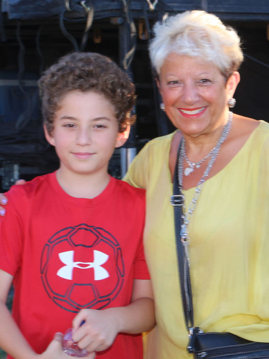 Femme et garçon souriants posent. Sous Armour, détails vestimentaires. À PROPOS photos souvenirs.