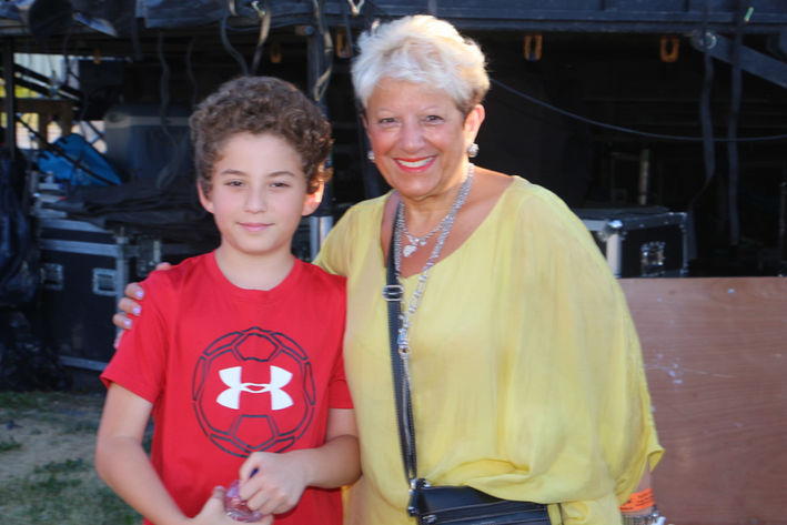 Un garçon et une femme souriant, vêtus de rouge et jaune, GALERIE.