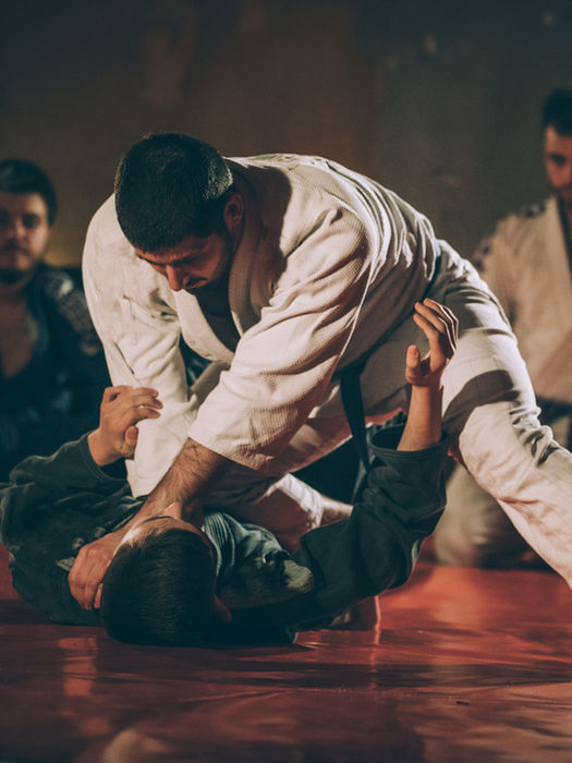 Deux hommes en kimono s'entraînent au jiu-jitsu.