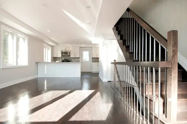 Bright interior of a home with a staircase. HOME, hardwood floor and kitchen.