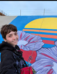 Nicoloe Lachele artwork on display at the Blo Back Gallery in Pueblo, CO April 2026. Nicole Lachele is an artist based in Southern Colorado whose work explores themes of resilience, transformation, and femininity, often drawing on her own personal struggles and inner conflicts.This series reflects a period of transformation, drawing on imagery from Sylvia Plath’s writing, most specifically The Bell Jar. These paintings explore the experience of choosing later than expected, yet making a choice nonetheless, and committing, imperfectly, to a new path despite uncertainty and fear.    I first encountered The Bell Jar and Plath’s fig tree metaphor during a time of major change. Though I had achieved many of the things I had long sought out and dreamt of, I realized I had no clear sense of who I was outside of being a mother, wife, sister, or daughter. Always something to someone else, I felt I had no identity of my own.    Plath’s image of the fig tree, with each fruit representing a different possible life, captured a fear that had been difficult to articulate: choosing one path meant losing all the others, and waiting too long could leave you nothing at all. I had made my choice long ago, and now could neither reclaim the past nor step into the future.    Realizing how closely I related to her work, and knowing how her life ended, forced a shift in me. I could no longer stay suspended in possibility. The longer I ruminated on the past, the longer I would remain there, doing nothing, wishing I’d done more. As important as being a wife and mother is to me, I felt an all consuming need to pursue my dreams as an artist, so I ate the second fig.