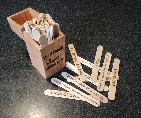 Personalized Sticks rummy game.  Front of wooden box can be lasered with a simple personalization.  Comes with 46 rummy sticks and an additional 18 "adult" sticks for a drinking game version.  4 decks of cards required for this game are not included in the price, but can be purchased separately.

Price $50