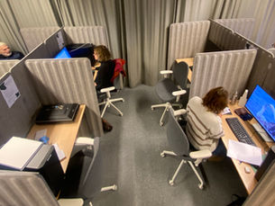 A view of SkillStation's workstations from above. There are some people in their cubicles.