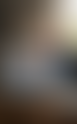 En man sitter vid ett skrivbord och interagerar med ett futuristiskt holografiskt gränssnitt som visar ett digitalt album med familjefoton, en bok och en karta. Bild skapad med Gemini.