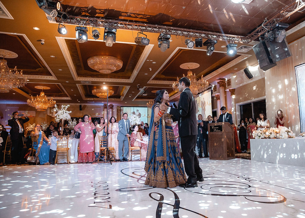 wide shot of bride and groom dance at the wedding reception hall