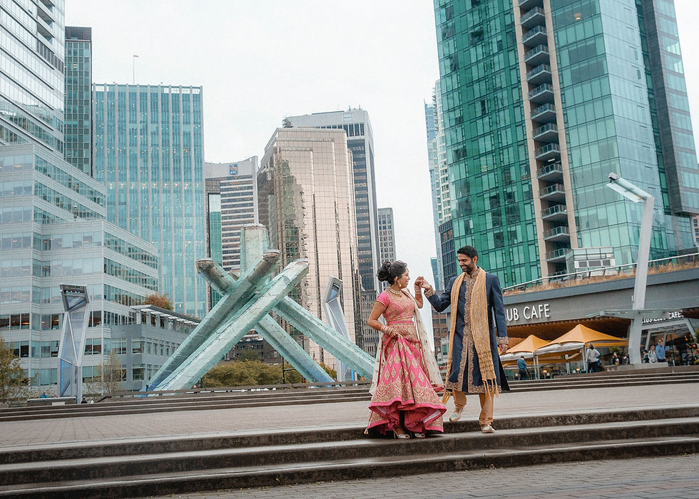 groom walks the bride down the stairs to a downtown backdrop
