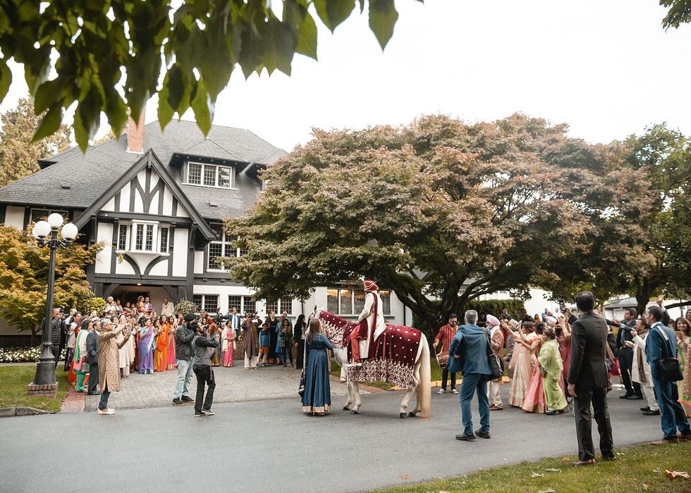 groom on horse in wide shot approaching a big mansion