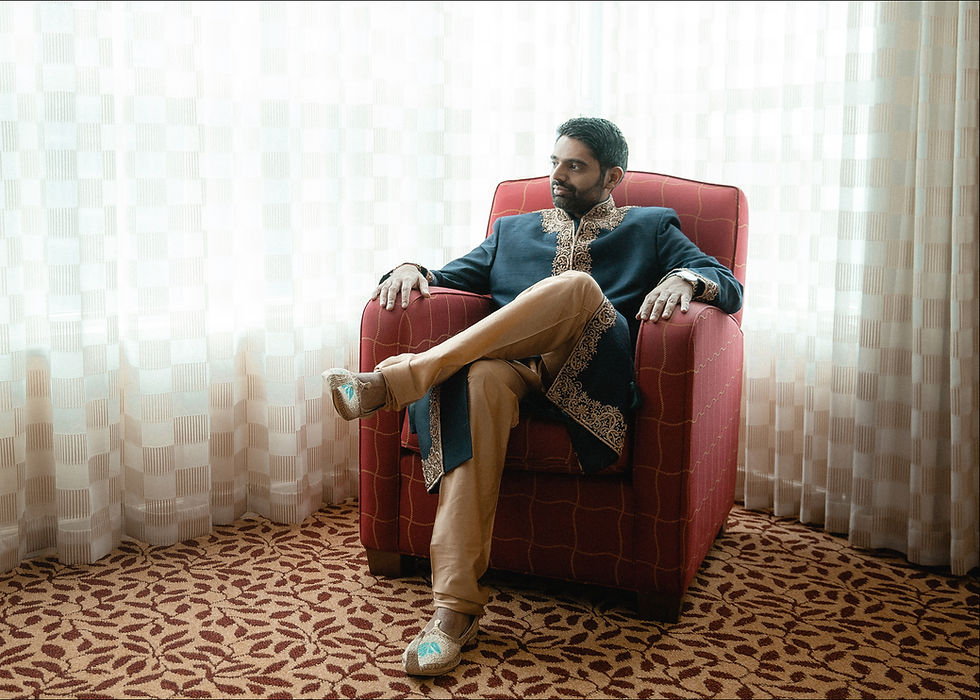 Groom sits in an armchair by the window