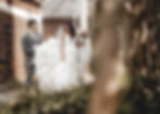 groom holds the brides dress while she looks down reflectively, they are both walking down a street by CWRU