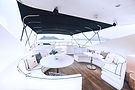 Yacht deck with white seating, tables, and distant mountains