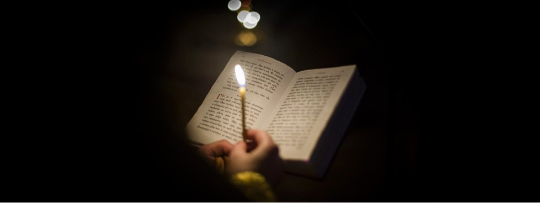 Holy Bible and the lighted candle.