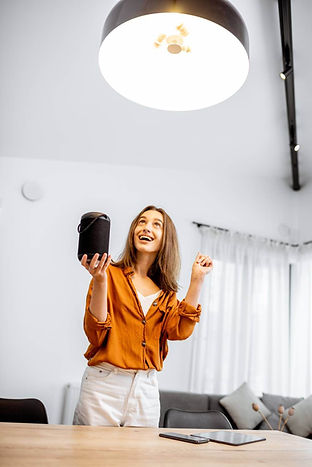 woman-controlling-light-with-a-smart-speaker-at-ho-2023-11-27-04-57-41-utc.jpg