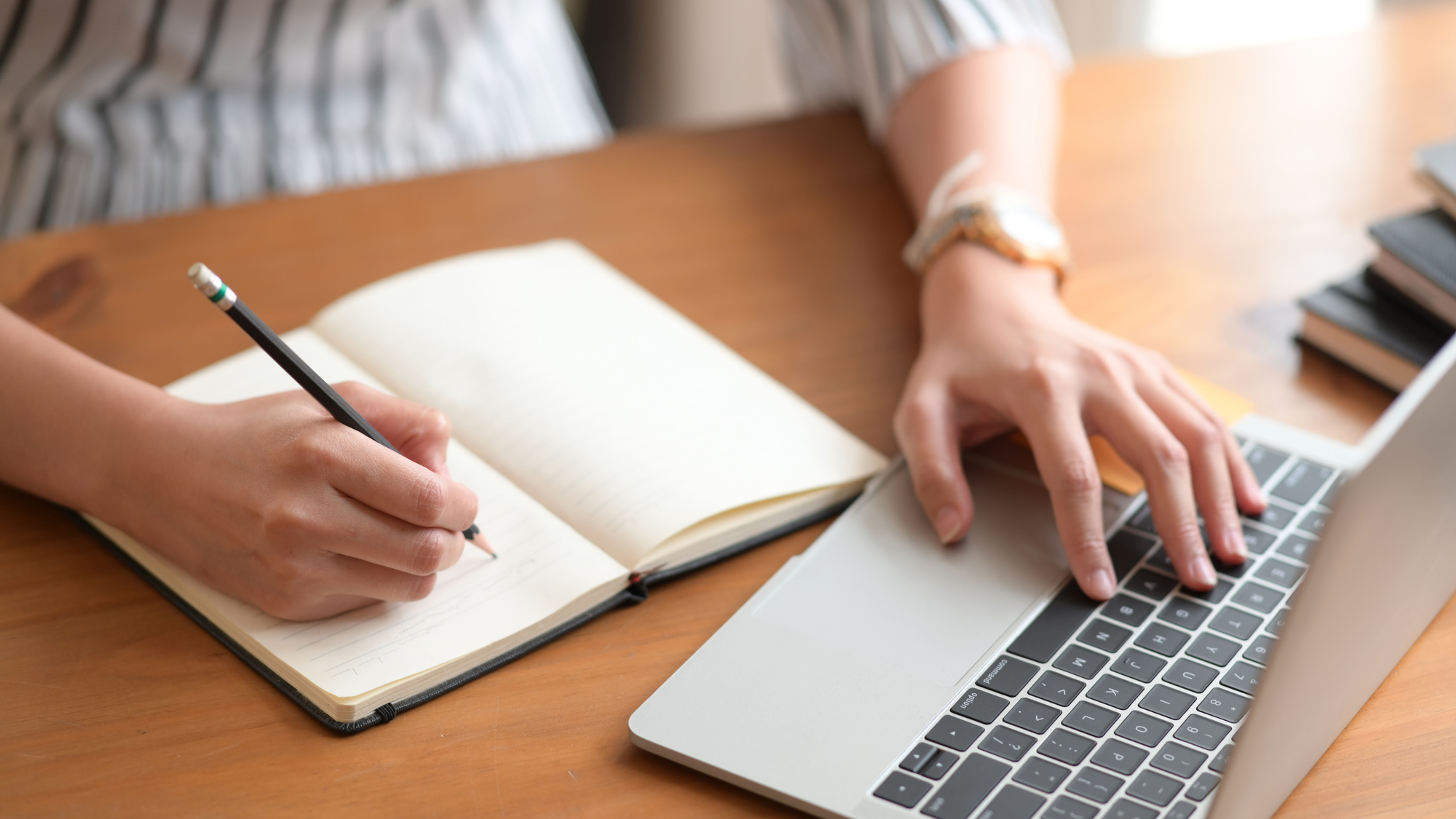Student working with a notebook and laptop