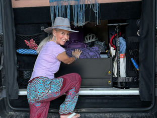 Debra loading her van with sound healing instruments, preparing for another journey on the open road. Ask ChatGPT