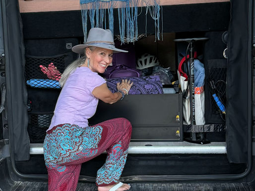 Debra loading her van with sound healing instruments, preparing for another journey on the open road. Ask ChatGPT