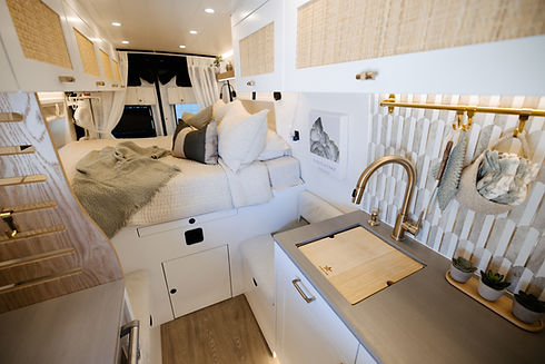 Custom Drifter Vans interior with queen bed and modern kitchen sink for comfortable vanlife living
