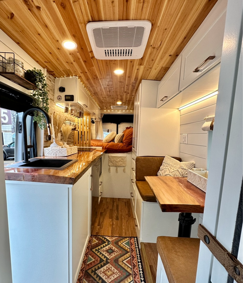 Interior design detail of Merideth’s camper van, featuring boho styling with soft textures, warm wood accents, and a cozy, lived-in aesthetic.