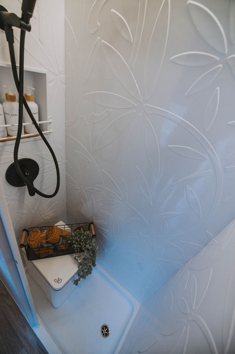 Fixed wet bath. Audray White panels, black rainfall system, white oak door, Trelino Tall. Nomadik.