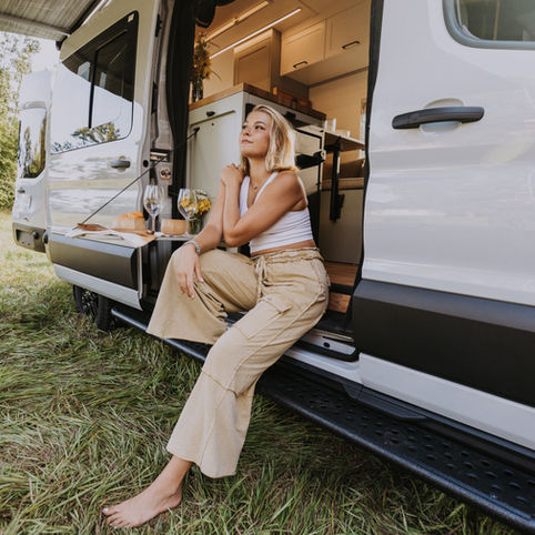 Beautiful woman looking over the horizon in her luxury camper van