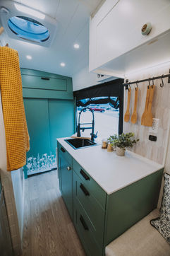 Kitchen zone, Nomadik layout. Aurora Magnolia countertop, Lehigh Green Shaker lowers, black sink.
