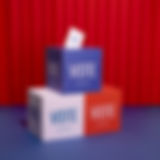 a stack of 3 different colored boxes that all contain the word Vote. One box is red, one white, and one blue.