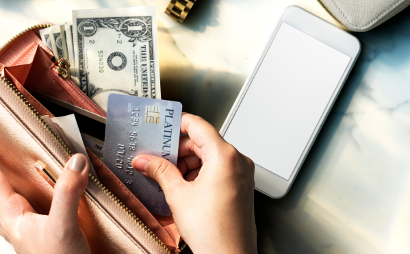 A person in their wallet, emphasizing smart financial decisions and budgeting for holiday season expenses.