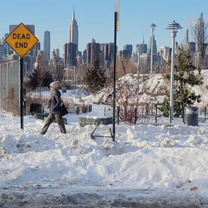 雪のニューヨーク、『DEAD END』の標識とマンハッタンの街並み