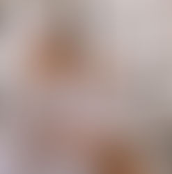 Woman in a white robe and towel turban eats dessert on a balcony with a city view. Sunny day, relaxed mood, wearing sunglasses.