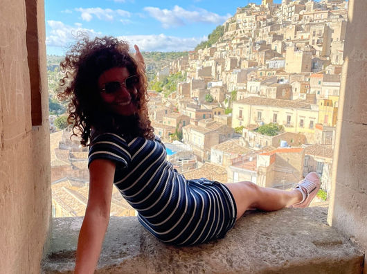 advanced hiking female sitting on the ledge of a windowsill in singles hiking tour group