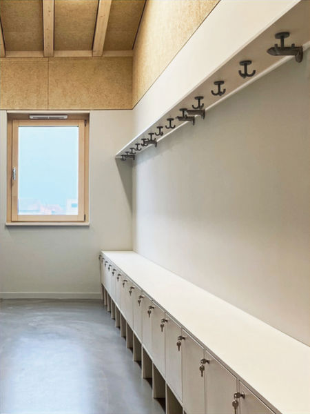Neubau von zwei Kindergärten in Edermünde. Umkleide der Mitarbeiter*innen mit Schließfächern gefertigt aus Birke Multiplex, Oberfläche weiß lasiert.