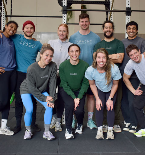 Coaching team of Kracht Amsterdam standing together inside the strength training gym in Amsterdam.