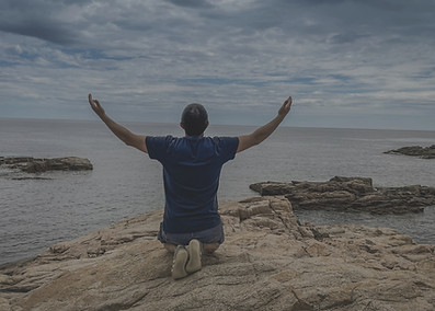a man sitting on top of a rock near the