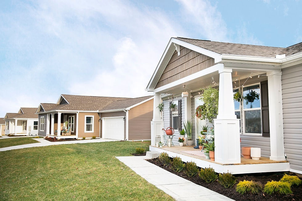 A picturesque suburban street features charming homes with welcoming porches adorned with hanging plants and outdoor decorations, set against a bright blue sky.