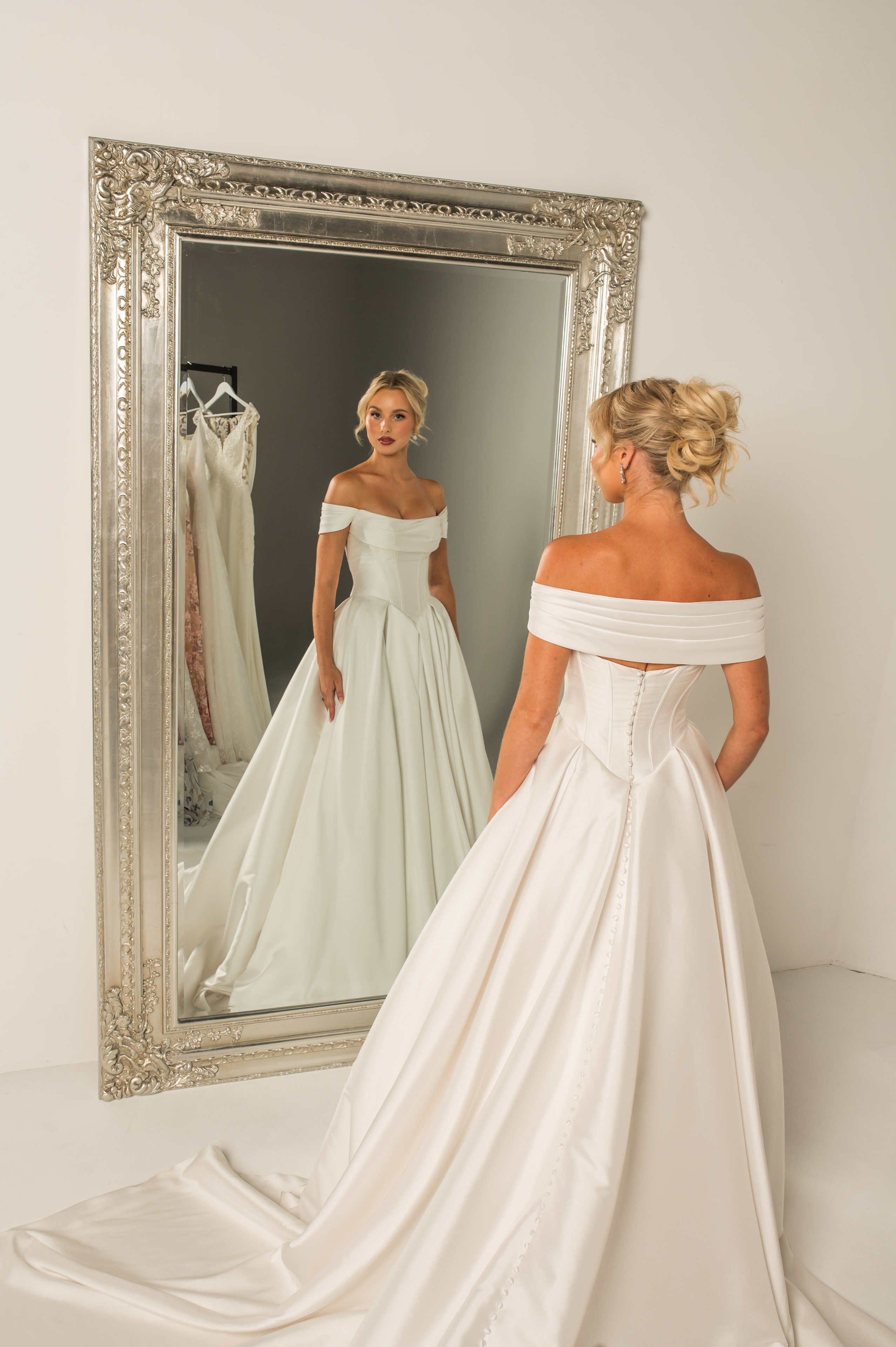 Strapless mikado ball gown with pleated scoop neckline, basque waist, and full pleated skirt with pockets