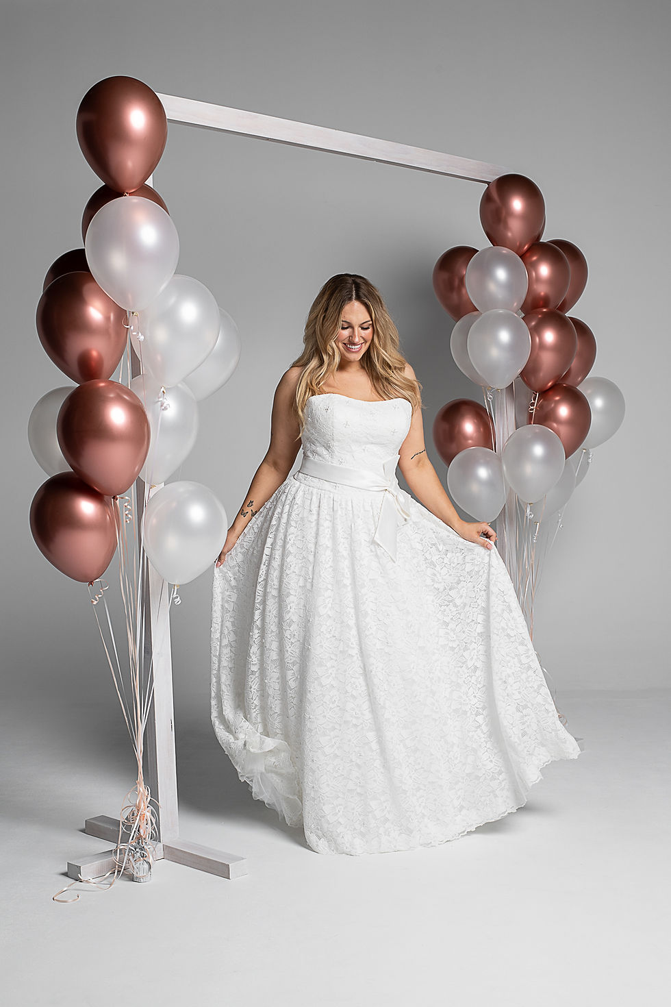 Front view: New Romantic GR299 by Gilded Rose strapless lace wedding gown with a full A-line skirt and a waist bow