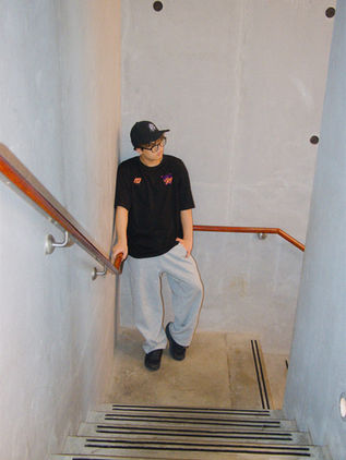 Dancer on a staircase wearing the black MUTE x LOVEURJAM tee
