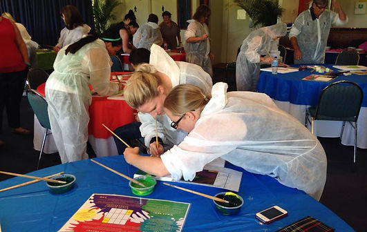 An enthusiastic team painting their image during a team building event by Sabre