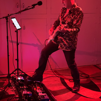 Guitar player engaging foot pedal